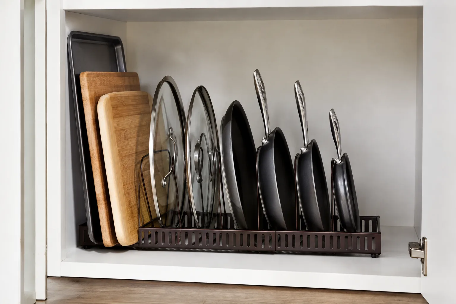 Mixed bakeware organized upright in a cabinet